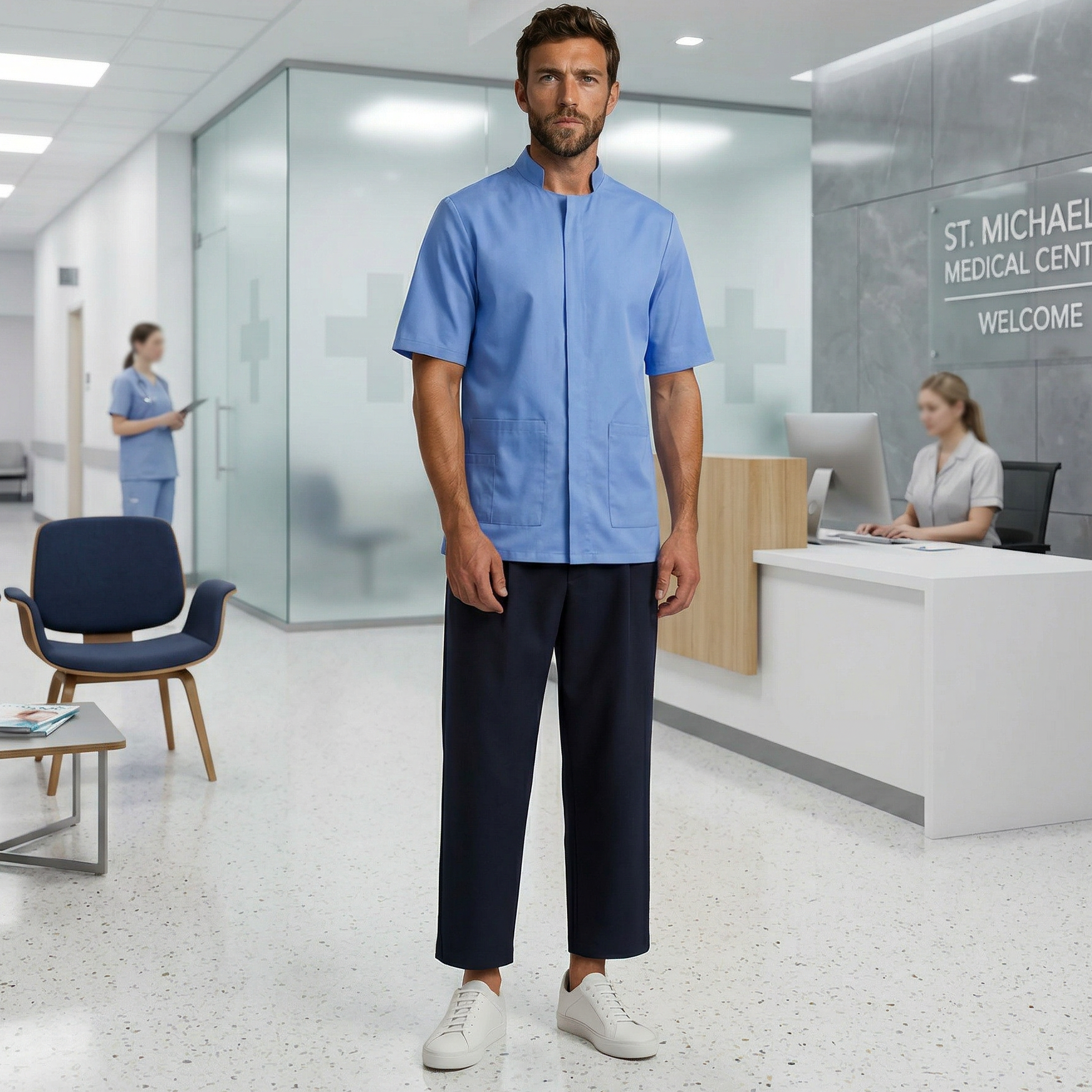 Man in blue medical scrubs standing in a modern hospital lobby.