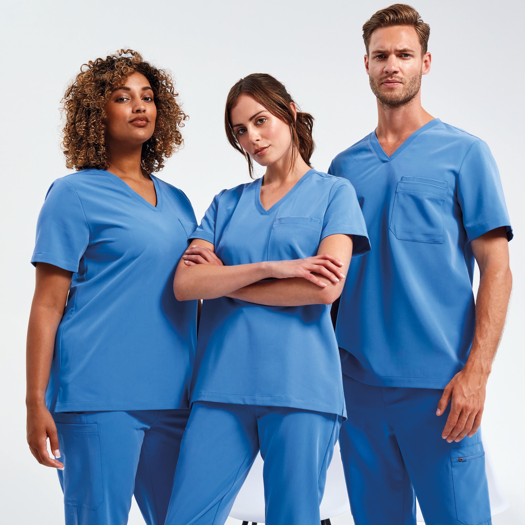 Two woman and a men wearing Onna Scrubs. The scrubs are medical scrubs but can also be used as salon scrubs. The scrubs are in blue 