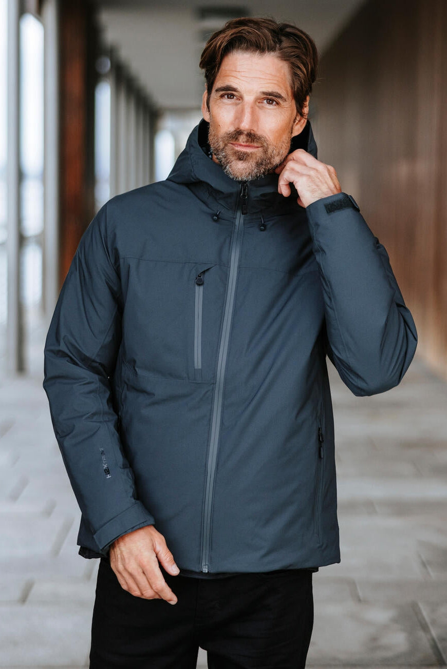 Man wearing a dark blue jacket in an indoor setting